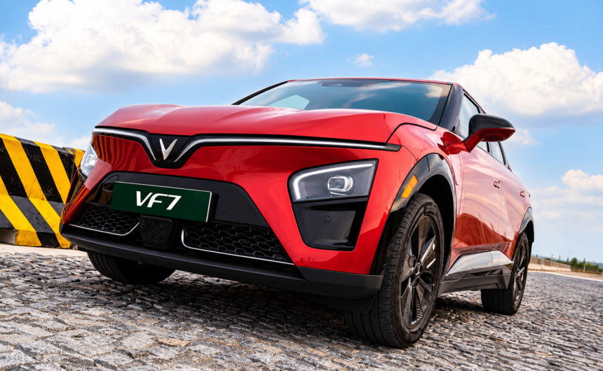 Red VinFast VF 7 electric SUV illustrating fuel savings from EV ownership.